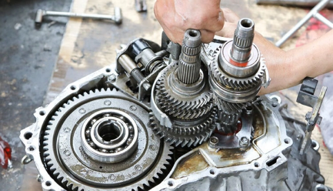 مکانیک در حال تعمیر گیربکس. تعمیر گیربکس اتومات